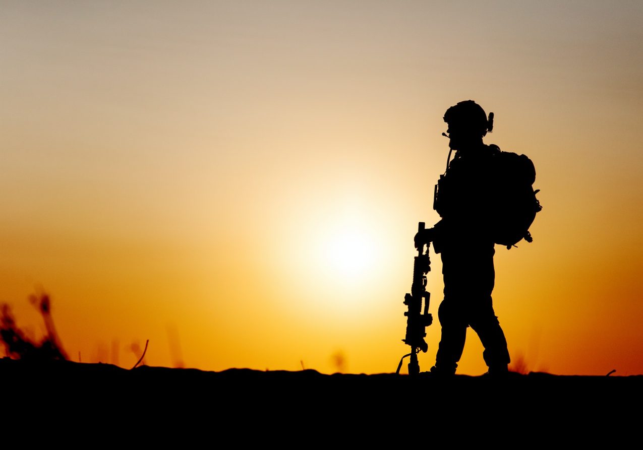 Army soldier silhouette on rising sun background